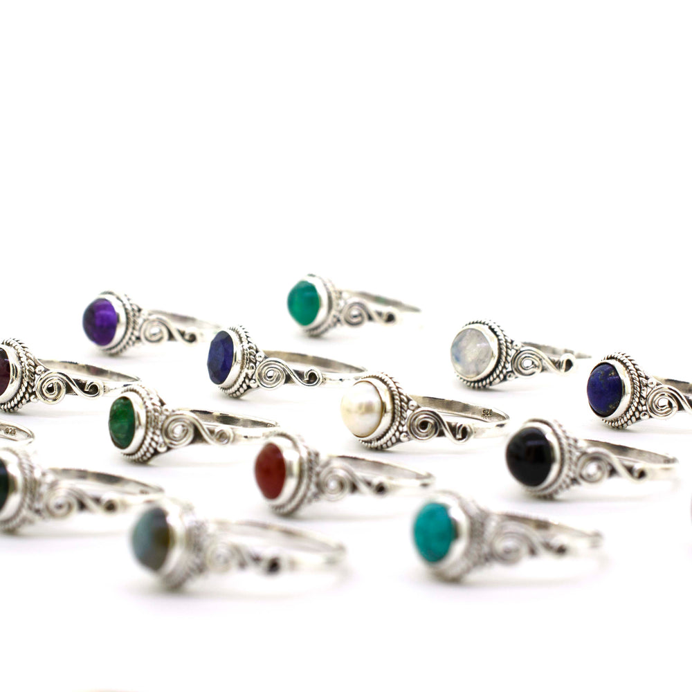A group of Gemstone Circle Rings With Rope Border And Swirl Design, including cabochon stones.