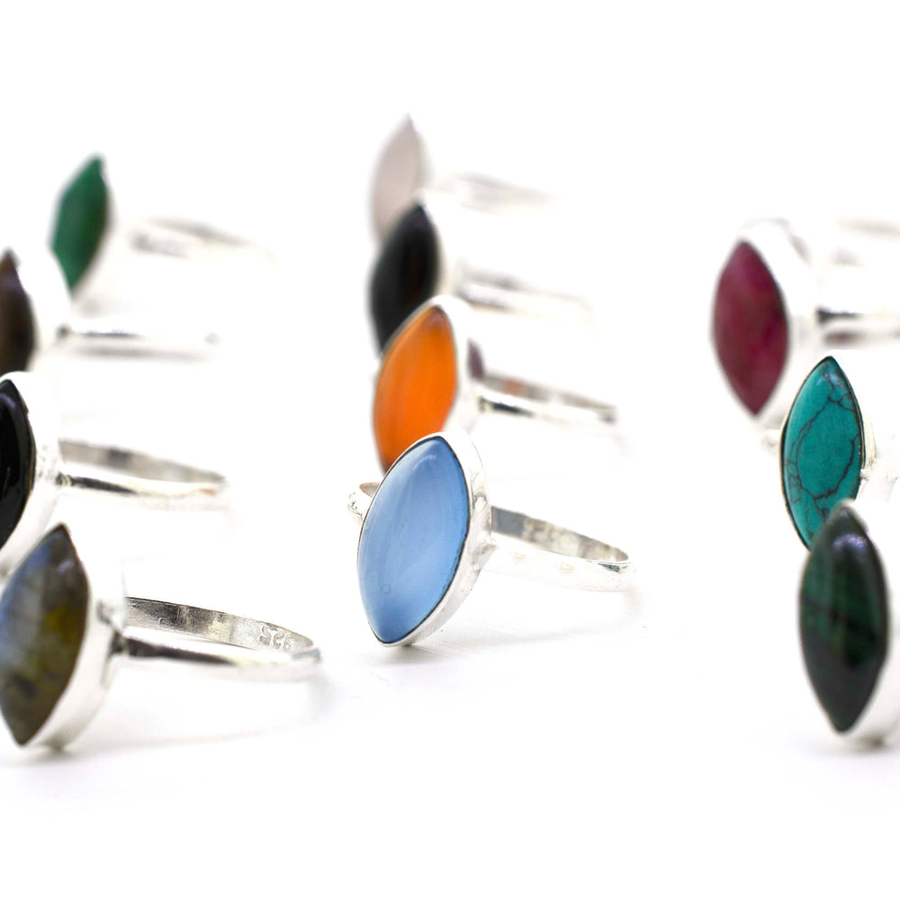 
                  
                    A group of colorful Simple Marquise Shaped Gemstone Rings on a white background.
                  
                