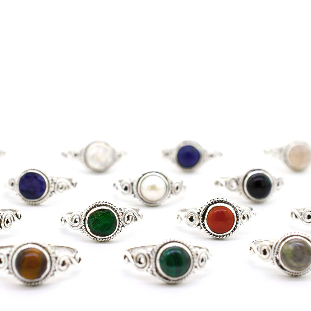 
                  
                    A group of Gemstone Circle Rings With Rope Border And Swirl Design on a sterling silver background.
                  
                
