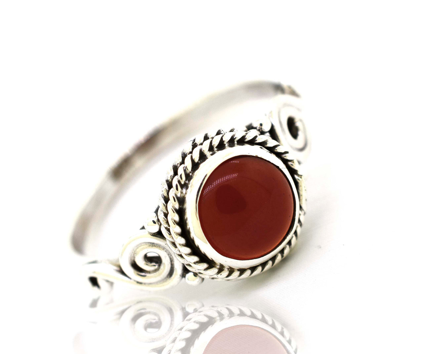 
                  
                    A Gemstone Circle Ring With Rope Border And Swirl Design with a red stone.
                  
                