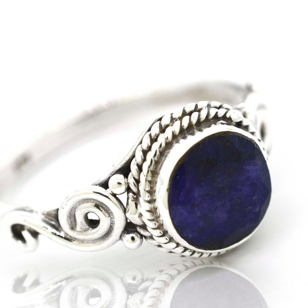 
                  
                    A Gemstone Circle Ring With Rope Border And Swirl Design with a lapis stone in a cabochon setting.
                  
                