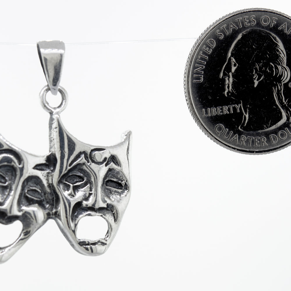 
                  
                    This Laugh Now Cry Later Pendant by Super Silver features two theatre masks.
                  
                