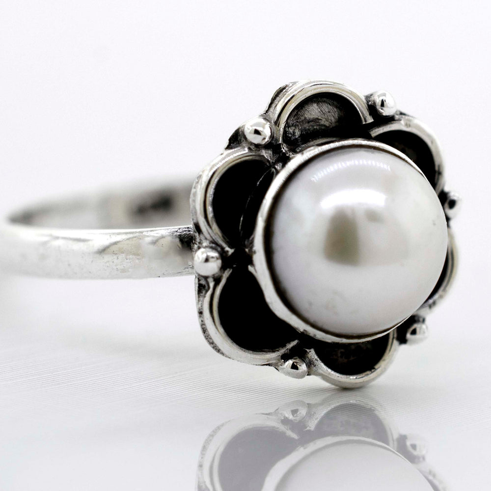 
                  
                    A delicate Super Silver Gemstone Ring With Oxidized Flower Design with a central gemstone placed on a white surface.
                  
                