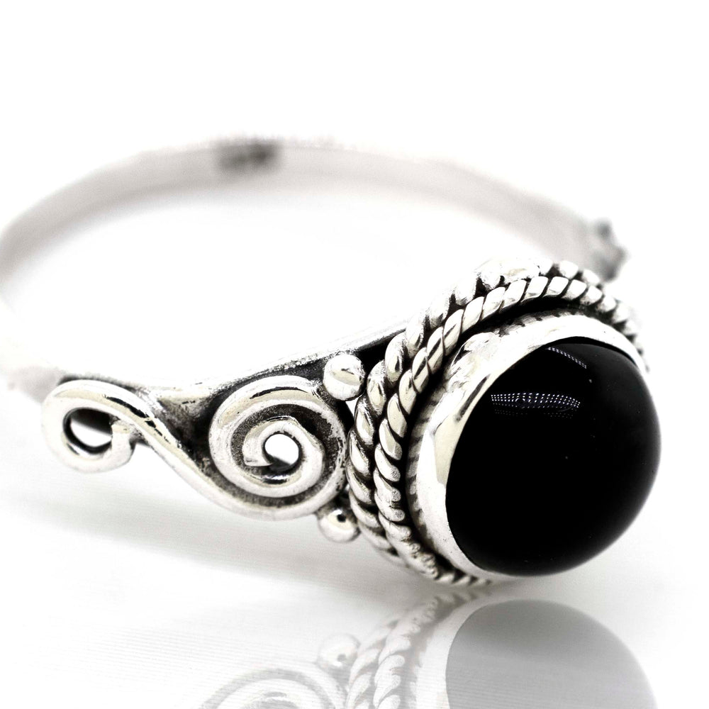 
                  
                    A Gemstone Circle Ring With Rope Border And Swirl Design made by Super Silver, exuding a bohemian vibe.
                  
                