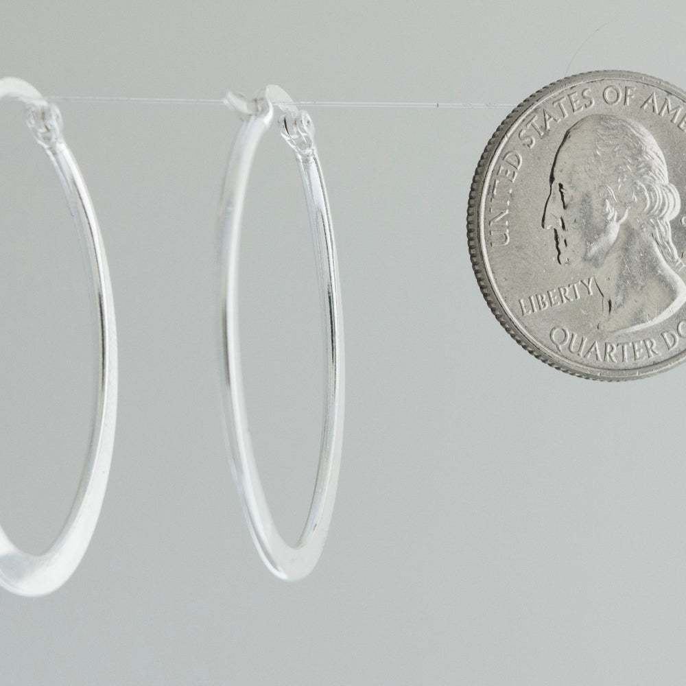 A minimalist Oval Shaped Hoops and coin earrings handcrafted from sterling silver by Super Silver.