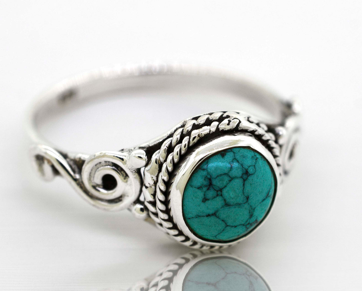 
                  
                    A Super Silver Gemstone Circle Ring With Rope Border And Swirl Design with a bohemian vibe and a turquoise gemstone.
                  
                