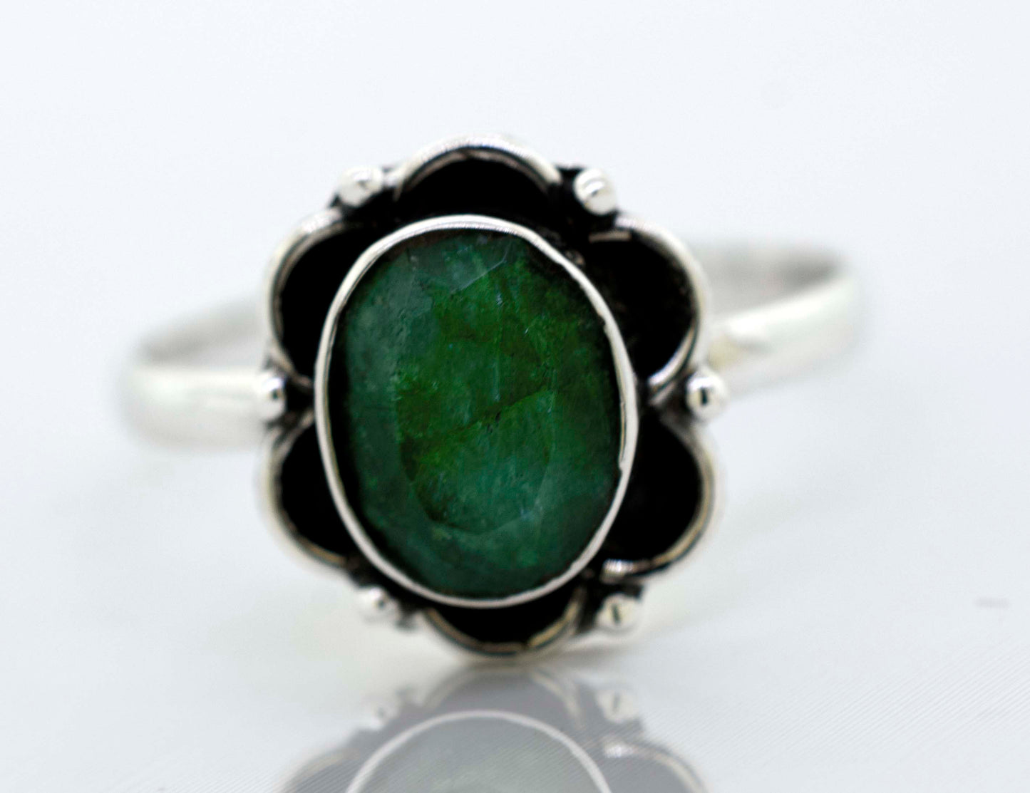 
                  
                    A delicate Super Silver Gemstone Ring With Oxidized Flower Design with a central green gemstone surrounded by black stones.
                  
                