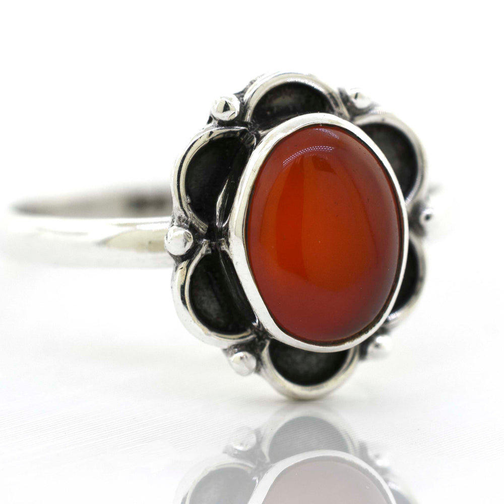 
                  
                    A delicate Super Silver gemstone ring with a central carnelian gemstone surrounded by delicate silver petals.
                  
                
