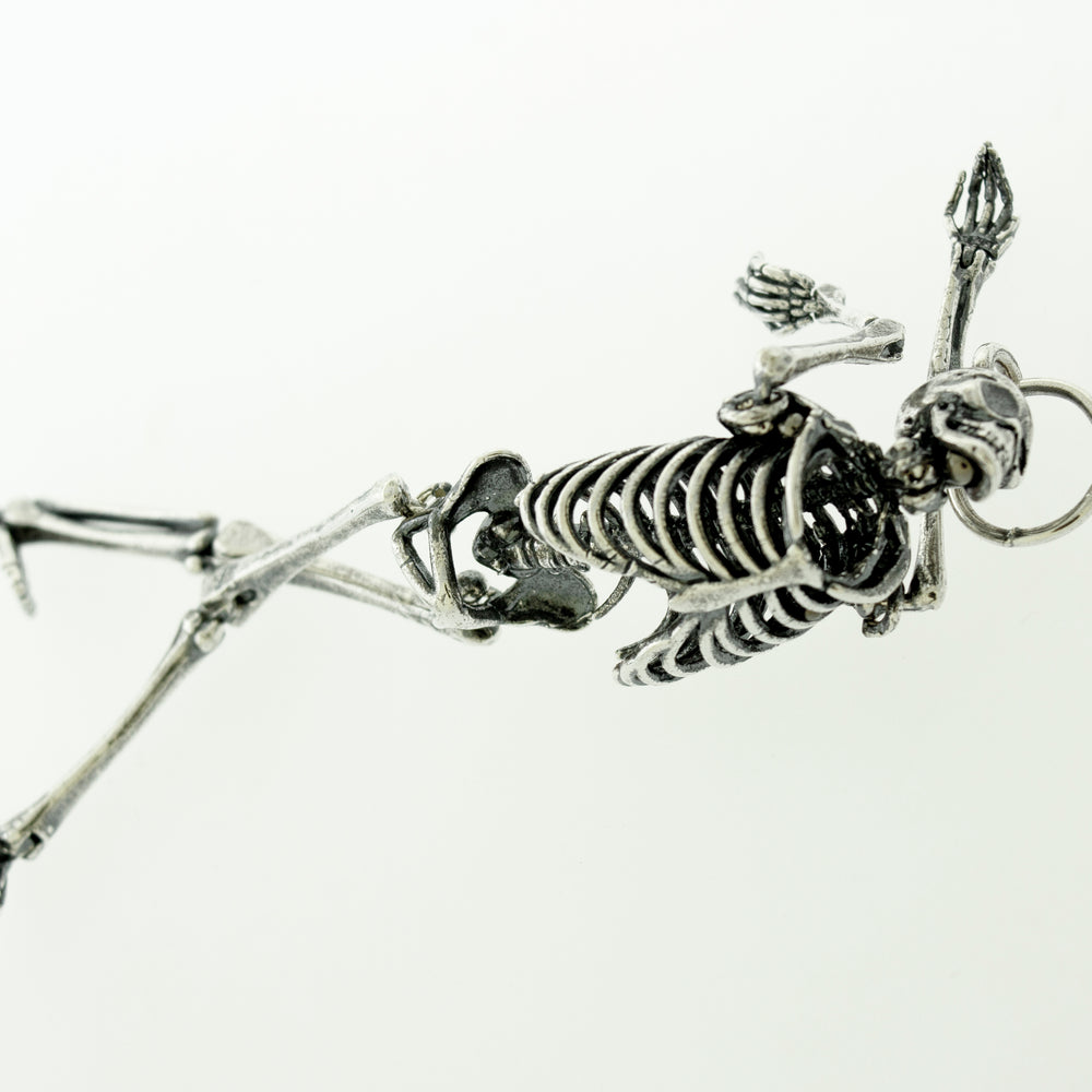 
                  
                    A statement piece, a Super Silver Large Skeleton Pendant, laying on a white surface.
                  
                
