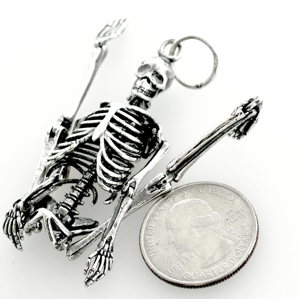 
                  
                    A stylish Super Silver Large Skeleton Pendant paired with a quarter, creating a statement piece.
                  
                