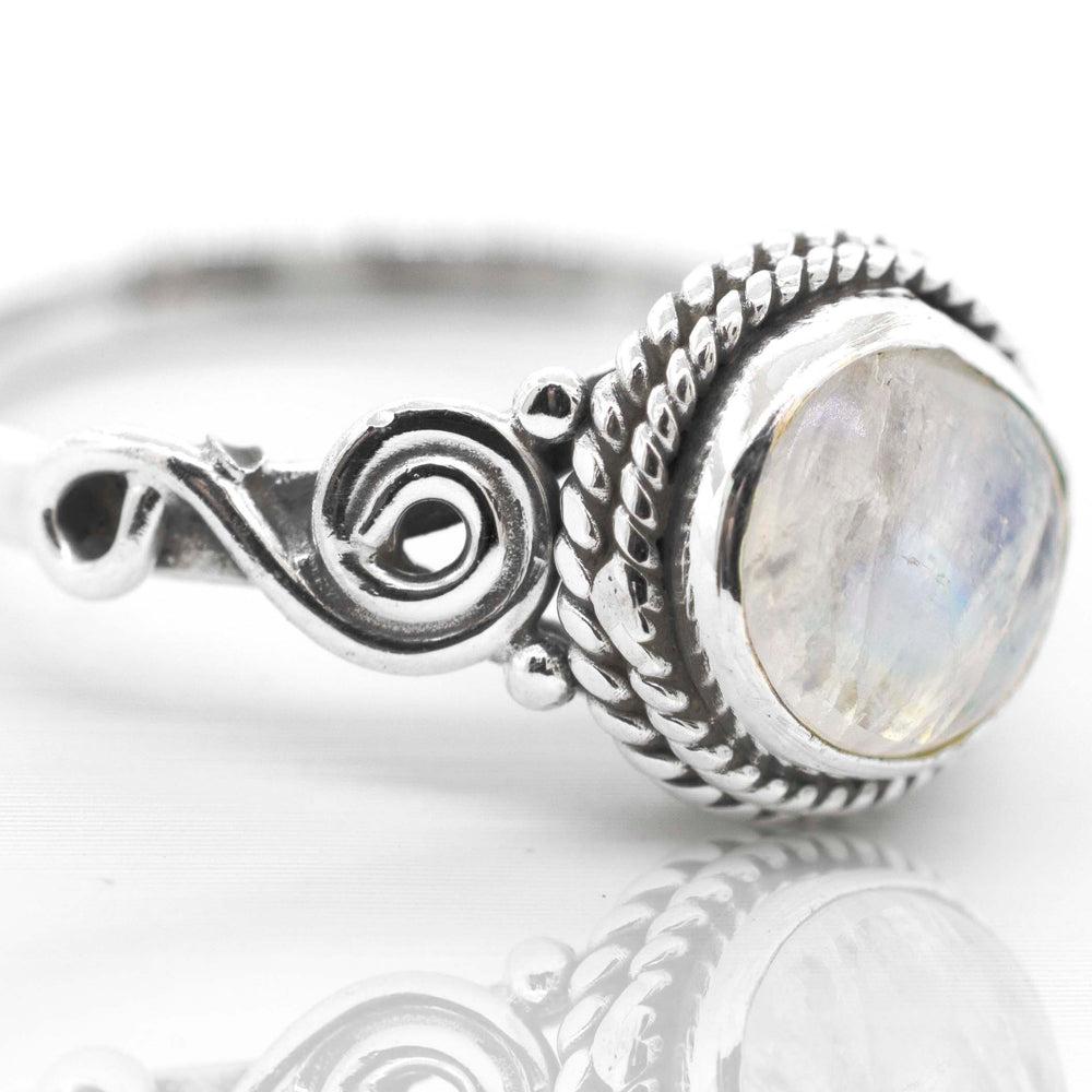 
                  
                    A bohemian vibe Super Silver Gemstone Circle Ring With Rope Border And Swirl Design with a moonstone in the center.
                  
                