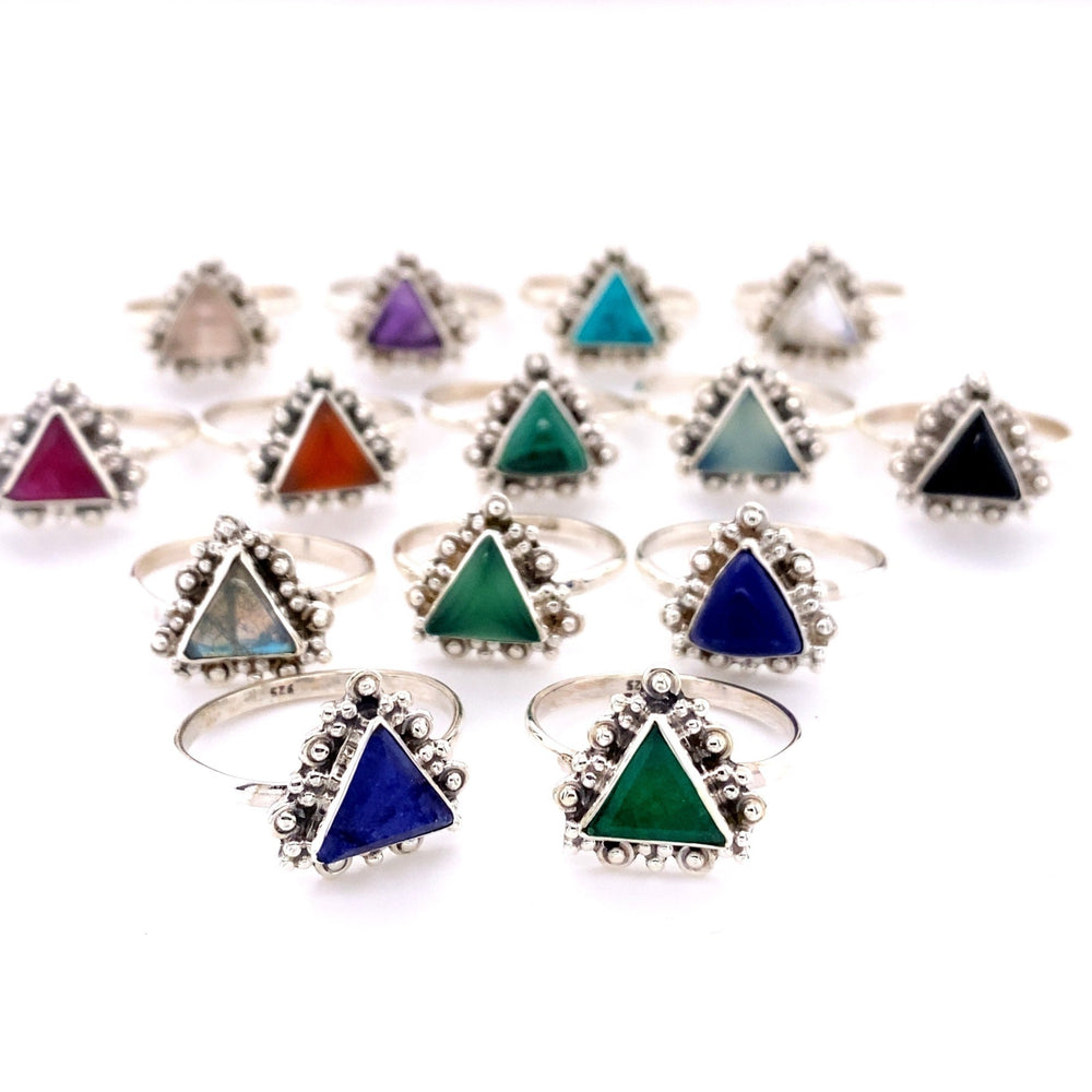 
                  
                    A group of Delicate Gemstone Triangle Rings with different colored stones.
                  
                