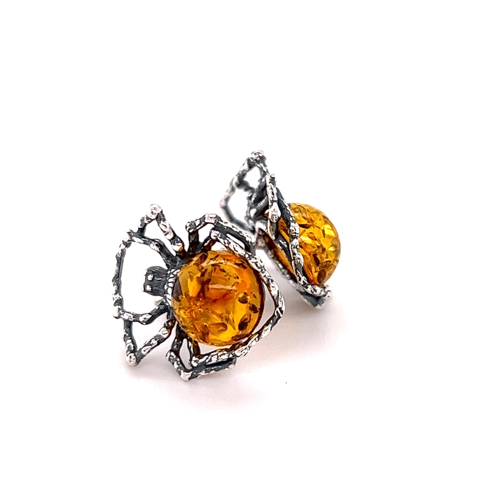 A pair of Eerie Amber Spider Stud Earrings by Super Silver on a white background, radiating self-empowerment.