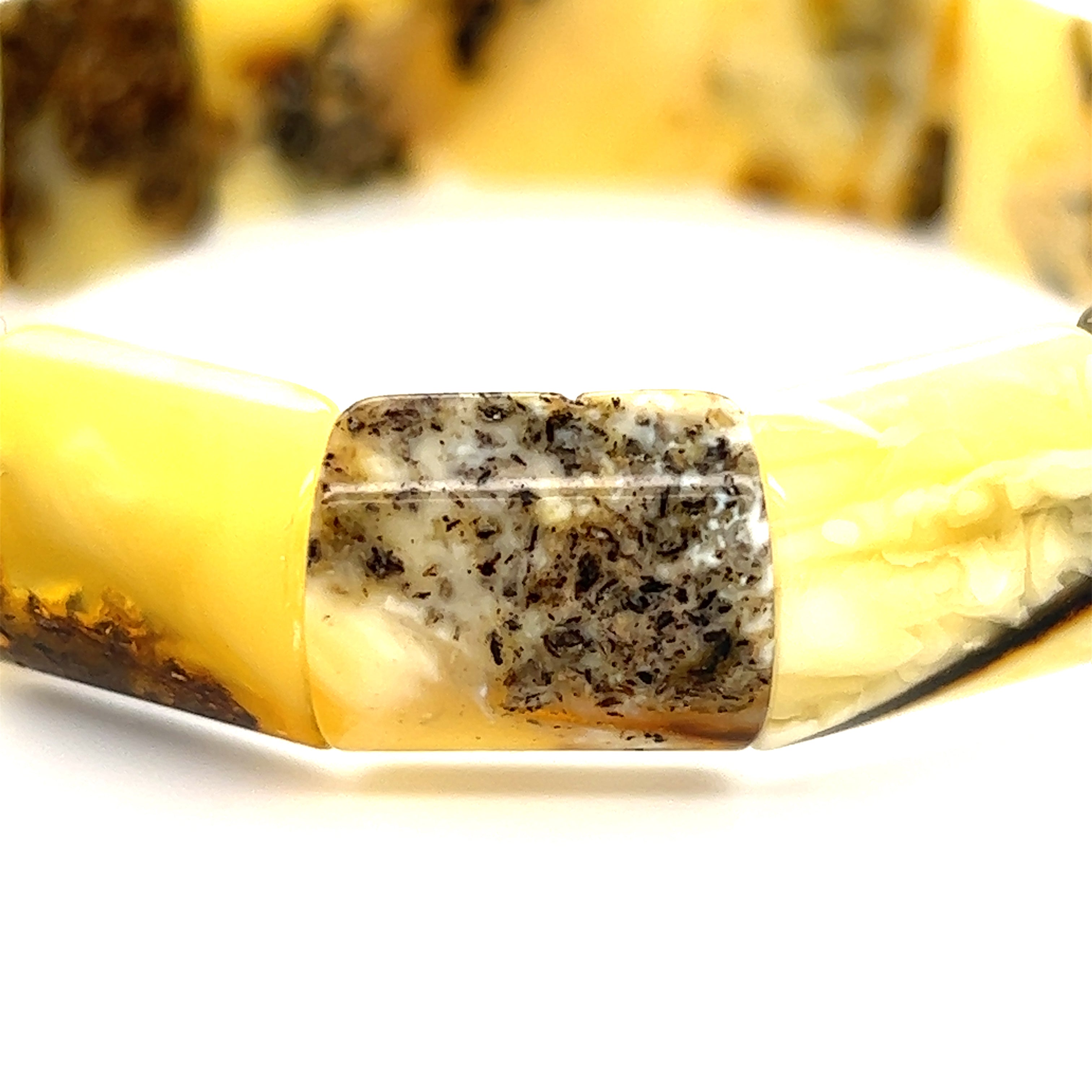 A Super Silver Brilliant Butterscotch Amber Stretch Bracelet with healing properties, crafted with yellow and black amber and adorned with butterscotch beads.