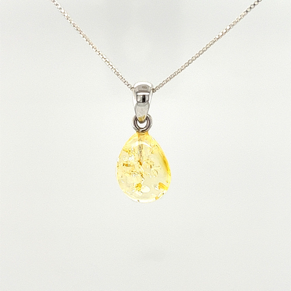 
                  
                    A Teardrop Amber Pendant made of Baltic amber, featuring a tear-shaped yellow stone, elegantly hanging on a Super Silver chain.
                  
                