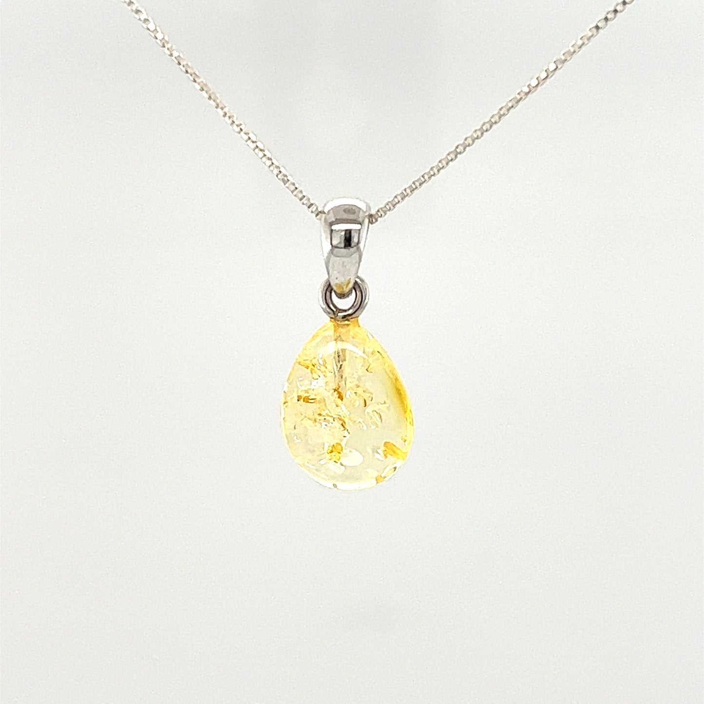 
                  
                    A Teardrop Amber Pendant made of Baltic amber, featuring a tear-shaped yellow stone, elegantly hanging on a Super Silver chain.
                  
                