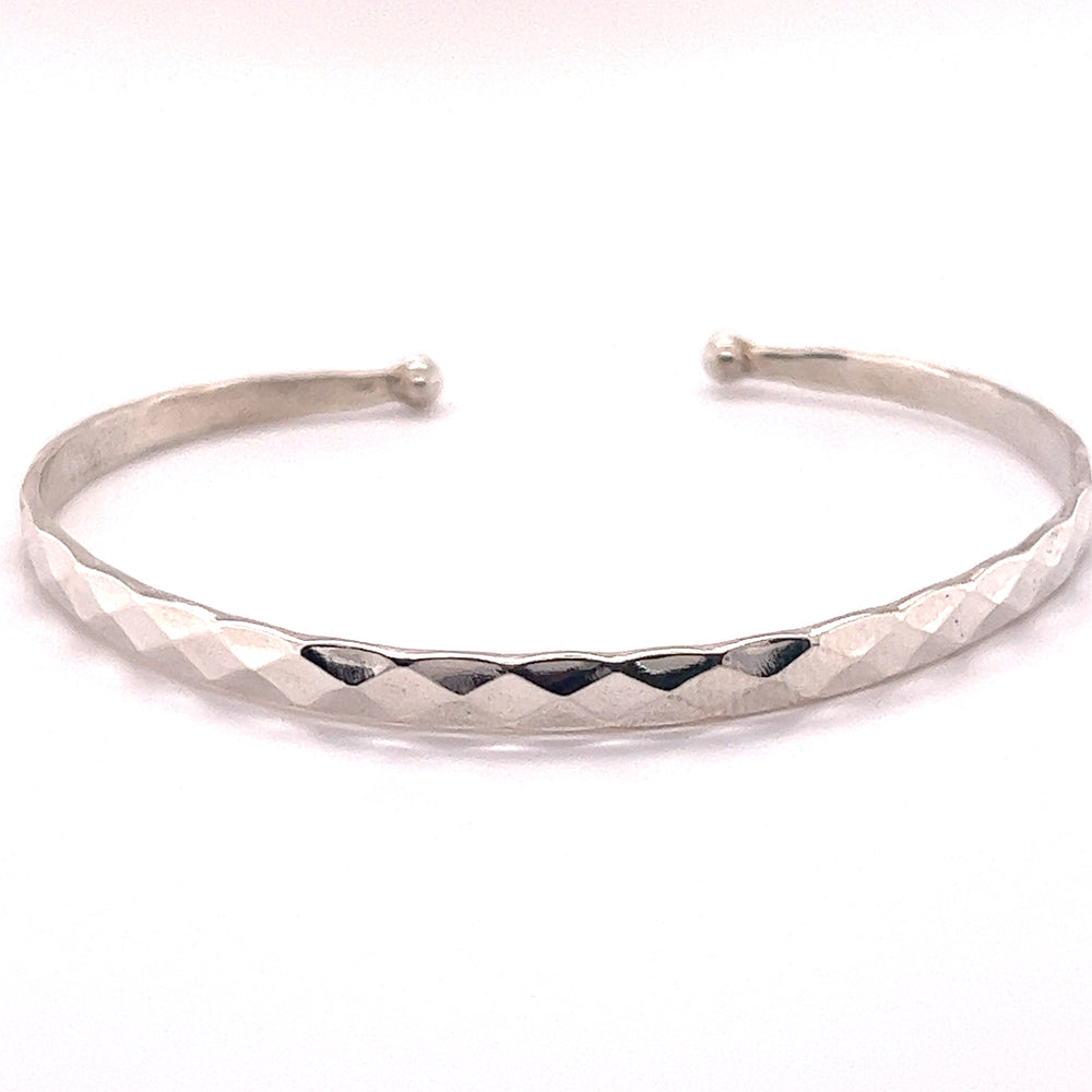 A shimmering Super Silver Stackable Hammered Cuff bracelet with a timeless diamond pattern, exuding glamorous elegance.