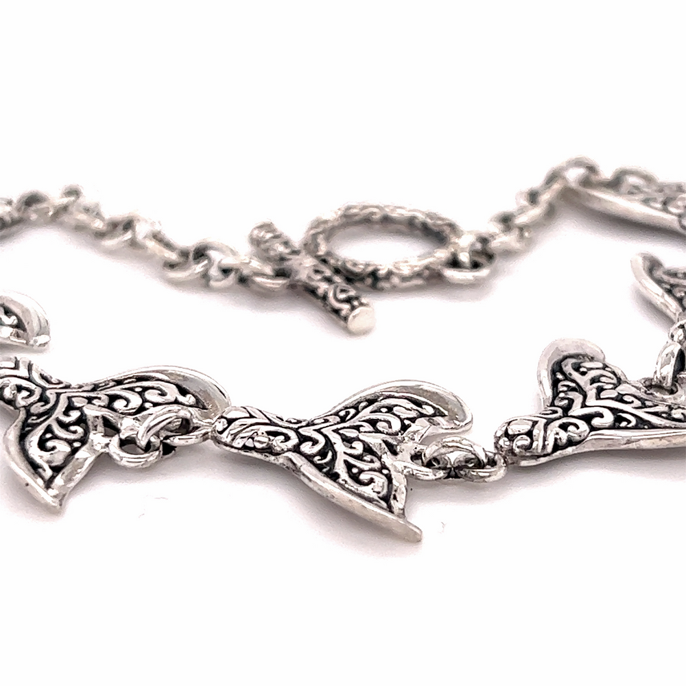 An ocean-themed Stunning Whale Tail Bracelet with ornate designs on it by Super Silver.