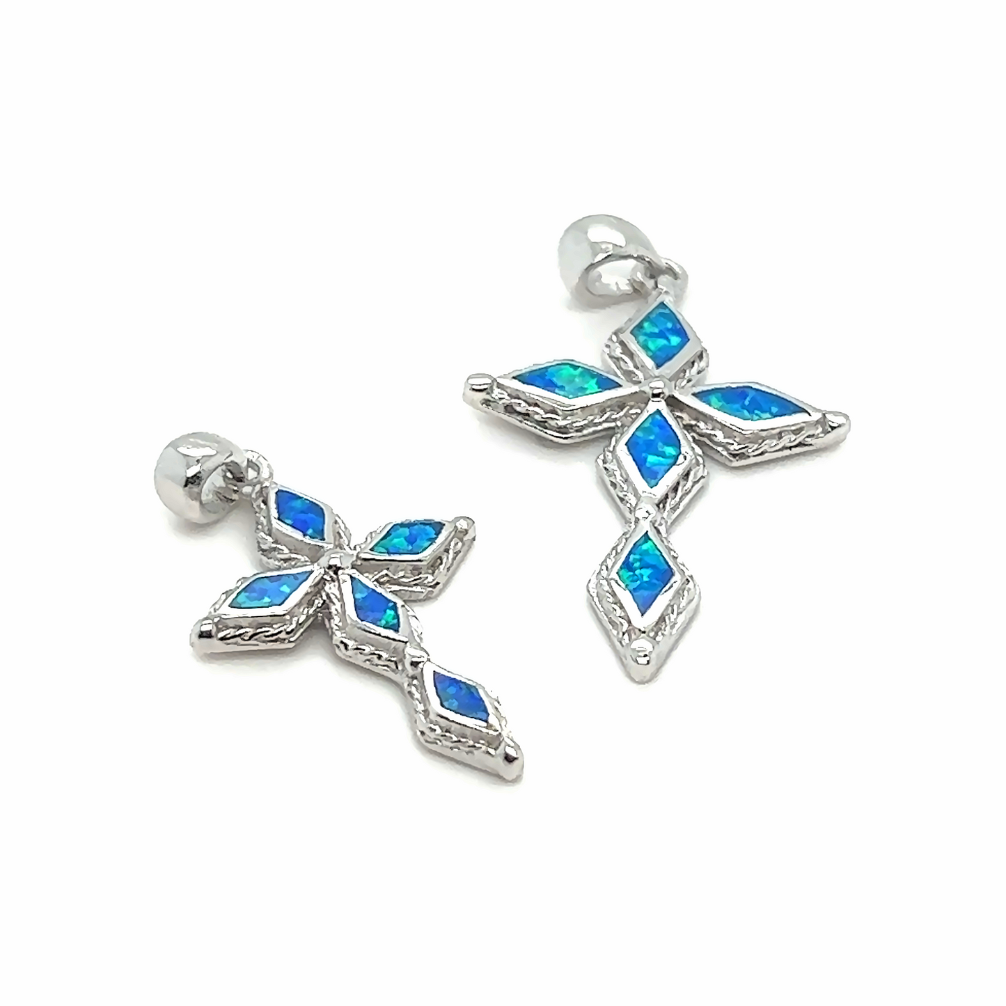 
                  
                    A pair of Super Silver Blue Opal Cross Pendants with diamond-cut blue opals and a rhodium finish.
                  
                