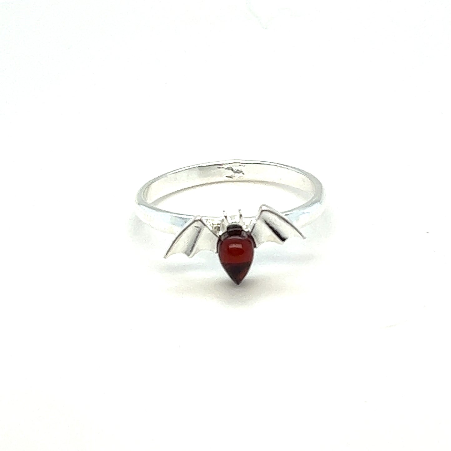 
                  
                    A Baltic Amber Bat Ring with a red garnet stone featuring witches, made by Super Silver.
                  
                