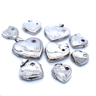 A collection of Super Silver's heart-shaped lockets with stone and lacy etching, exuding romantic charm, resting elegantly on a pristine white surface.