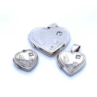 
                  
                    Three Super Silver heart shaped lockets with a romantic charm on a white surface.
                  
                