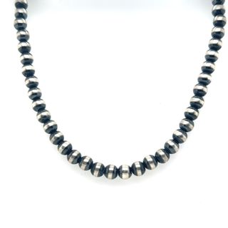 A Navajo Pearl Necklace by Super Silver with a vintage vibe, black and silver beaded necklace on a white background.