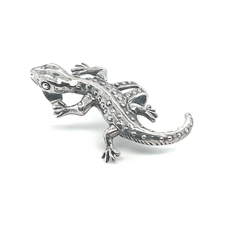 
                  
                    A resilient silver gecko on a white background with Super Silver's Unique Gecko Ear Cuff.
                  
                