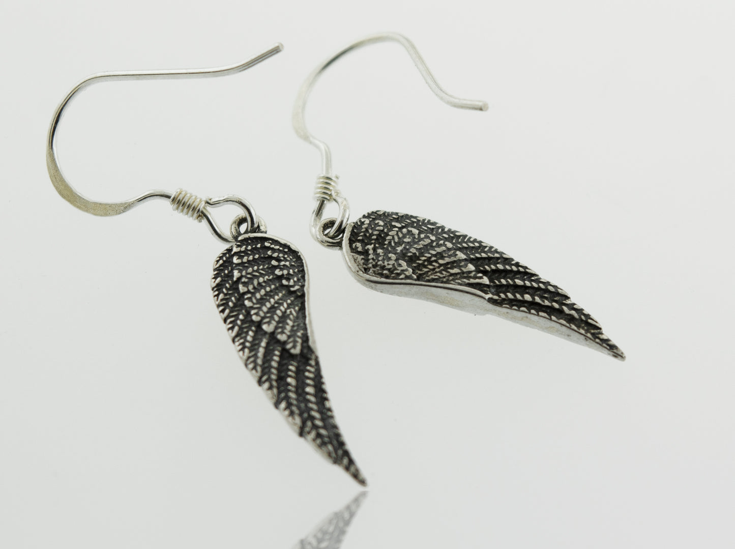 
                  
                    A pair of Super Silver Dainty Wing Earrings crafted from .925 sterling silver, displayed on a pristine white surface.
                  
                