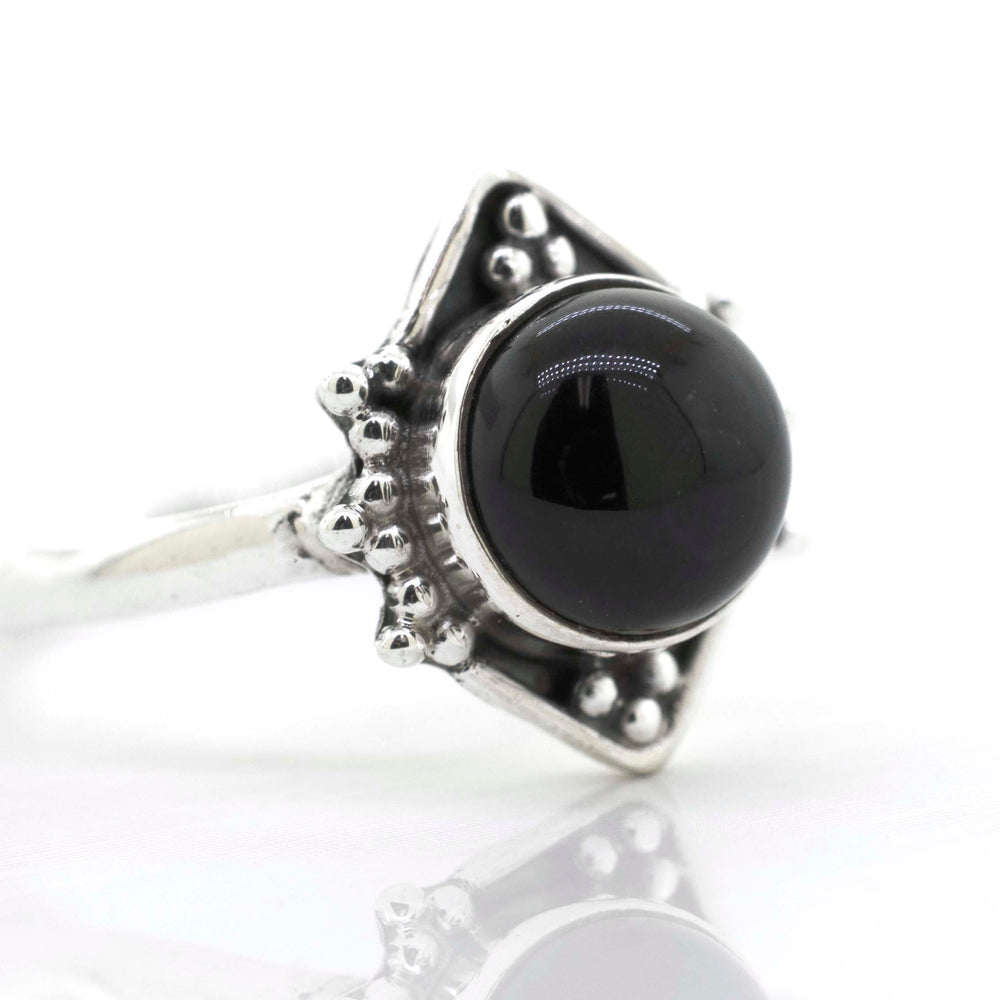 
                  
                    A Super Silver round gemstone ring with an oxidized diamond shape pattern, featuring a black onyx gemstone, on a white surface.
                  
                