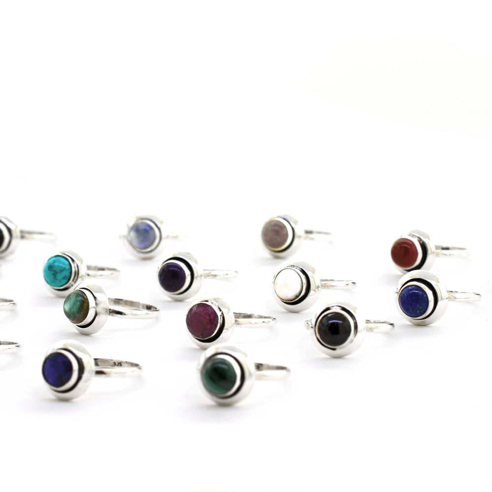 A Round Gemstone Ring With Oxidized Outline featuring cabochon stones in various vibrant colors.