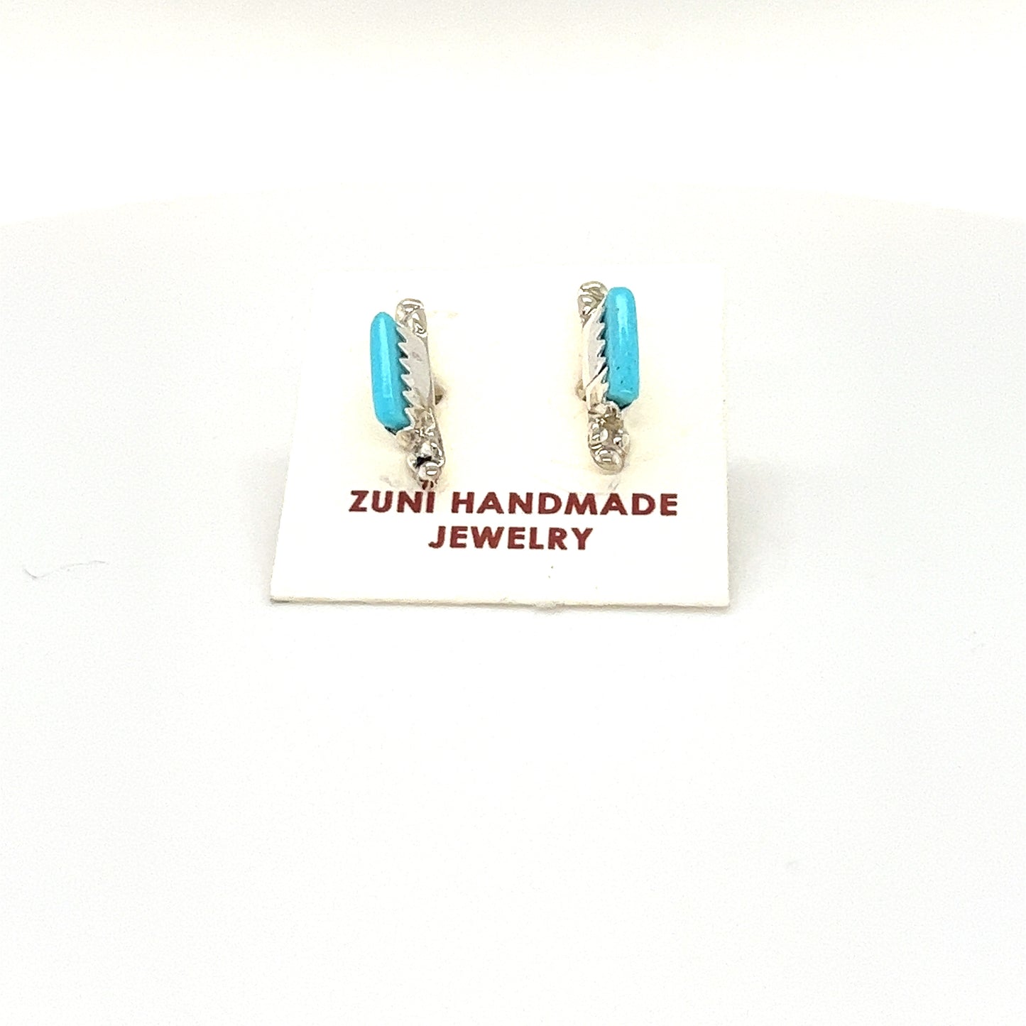 A pair of handcrafted Super Silver Zuni Turquoise Stud Earrings on a white background.