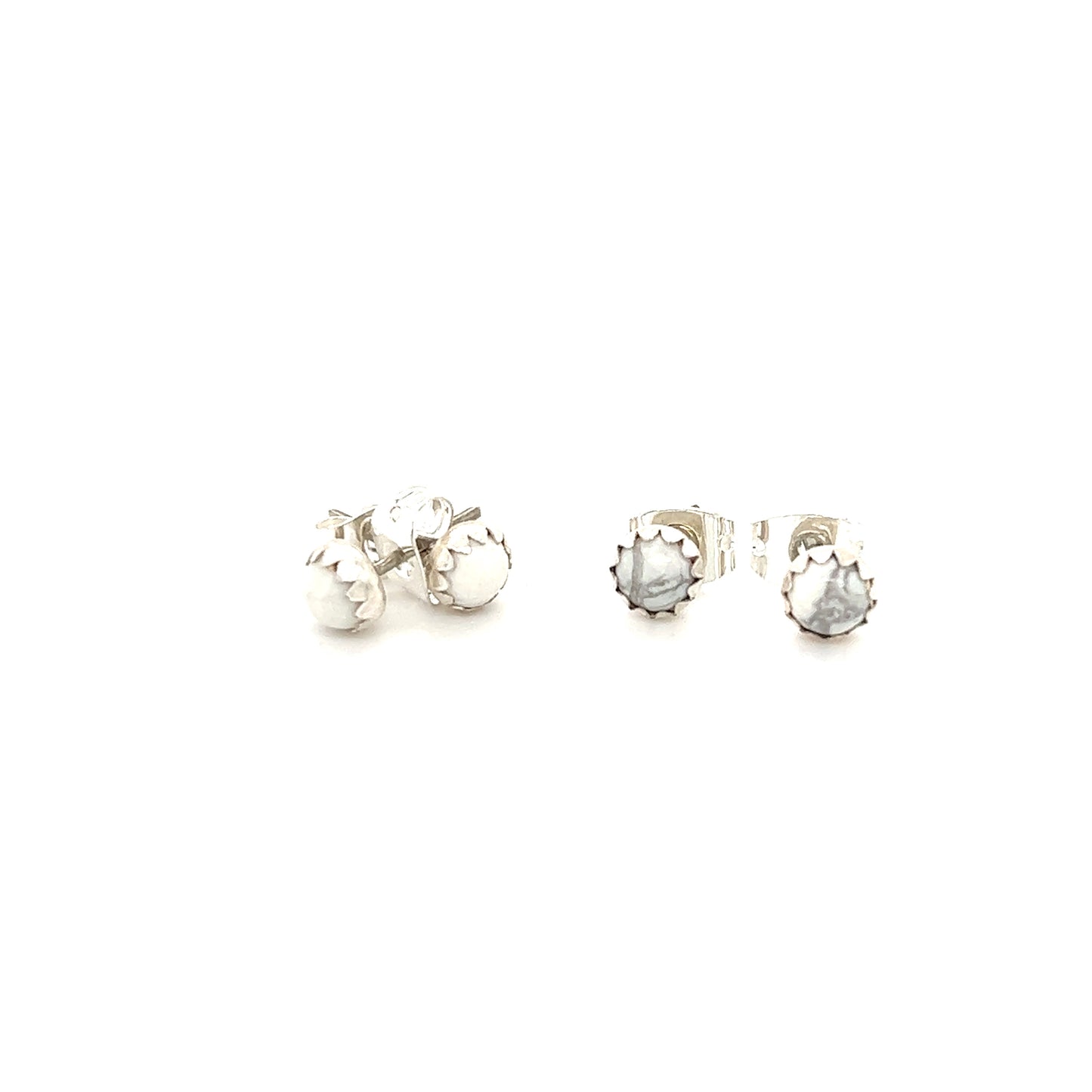 Delicate Super Silver handcrafted White Buffalo studs with a Native American vibe, showcased on a white surface.
