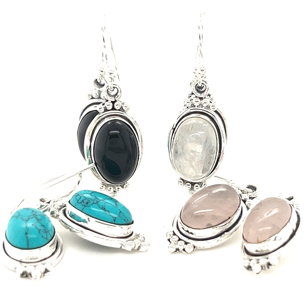A pair of Super Silver Natural Gemstone Earrings with a Raised Oval Setting adorned with beautiful gemstones in varying colors.