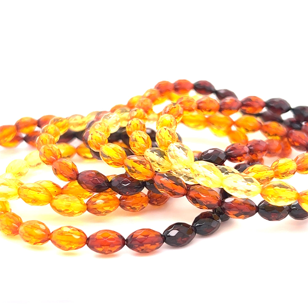 A stack of Super Silver Faceted Baltic Amber Stretch Bracelets, perfect for everyday wear or as a bracelet, arranged neatly on a white surface.