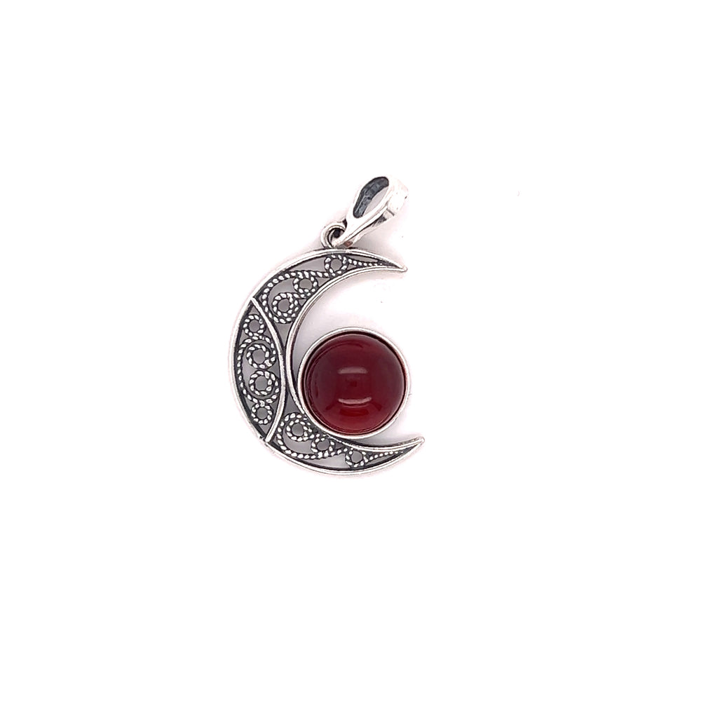 
                  
                    A Super Silver Baltic Amber Moon pendant with a red stone and a crescent.
                  
                