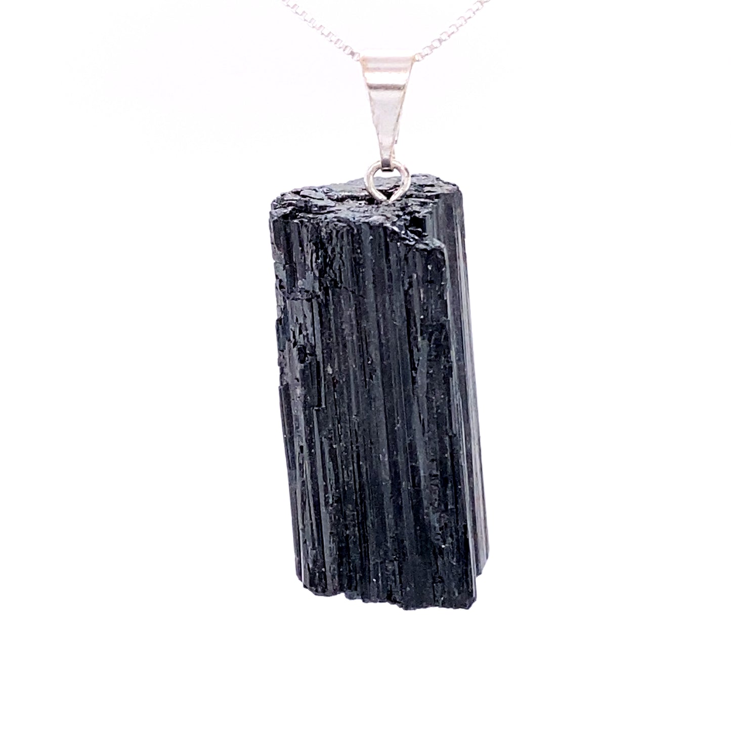 
                  
                    A piece of black tourmaline on a silver chain, alongside Super Silver crystal pendants.
                  
                