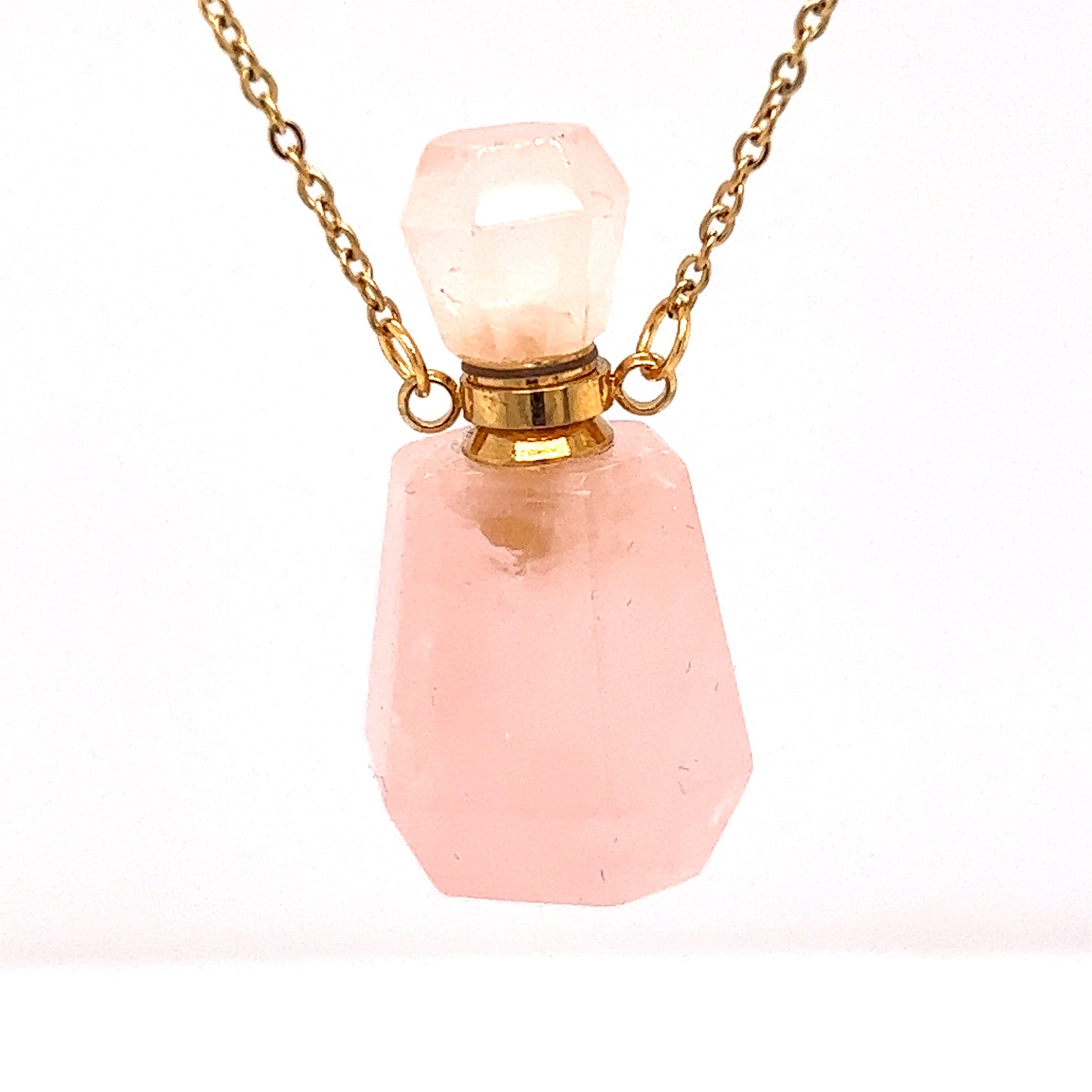 
                  
                    A Crystal Perfume Vial Necklace on a gold chain, featuring a pink quartz stone by Super Silver.
                  
                