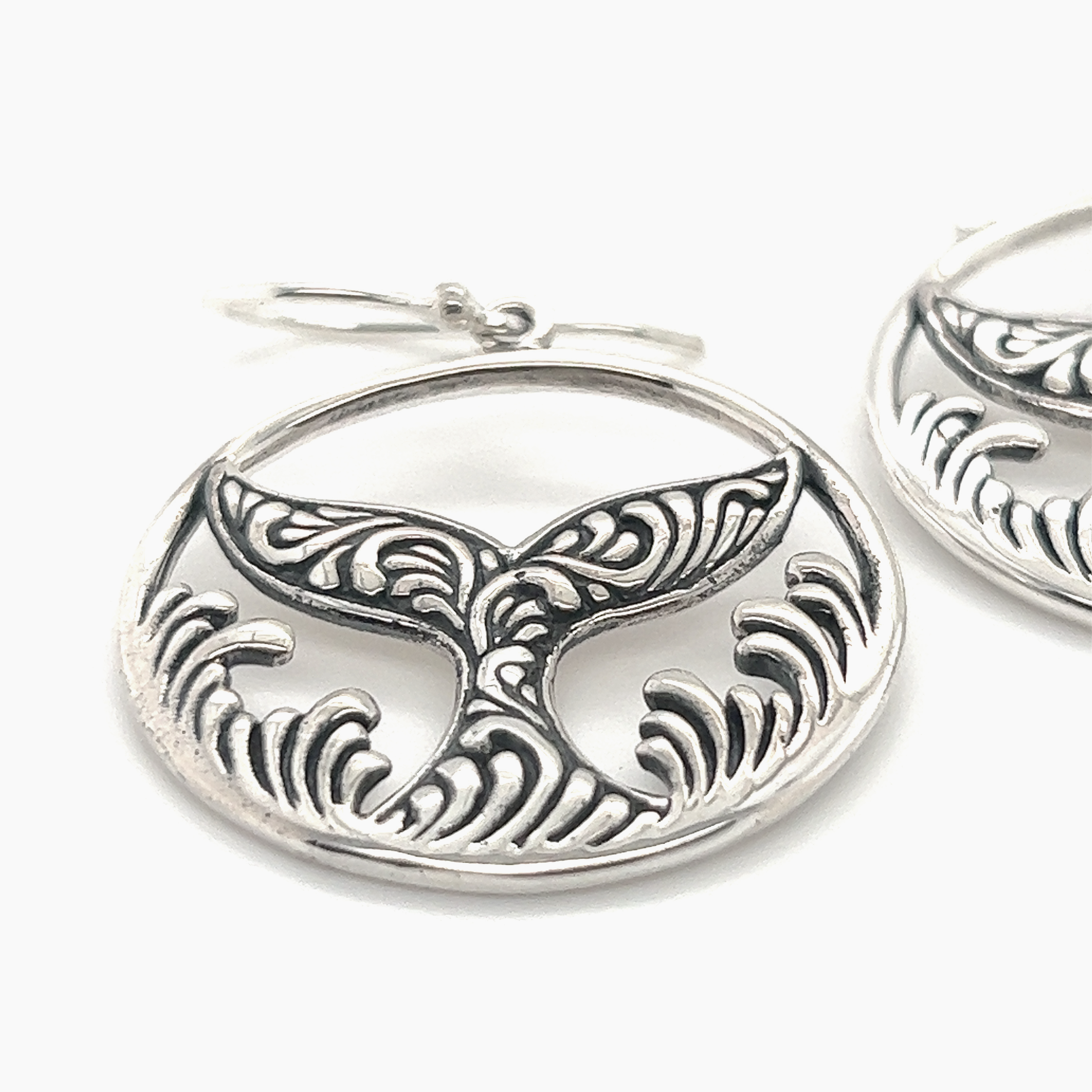 A pair of Enchanting Filigree Whale Tail Earrings by Super Silver, perfect for ocean lovers in Santa Cruz.