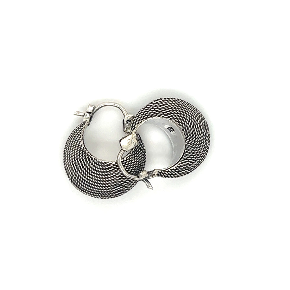 A pair of Dainty Bali Crescent Hoops with an oxidized finish on a white background, by Super Silver.