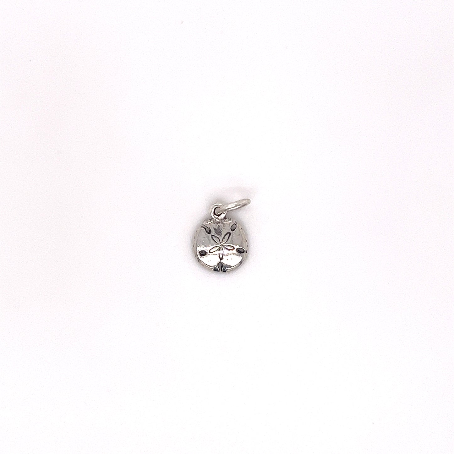A small silver Tiny Sand Dollar Charm with beach vibes on a white background by Super Silver.