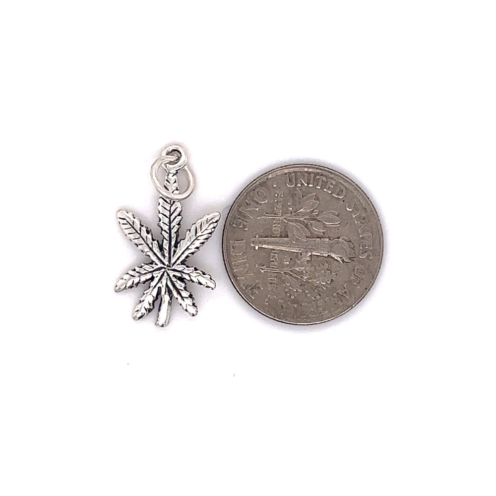 A Tiny Mary Jane Leaf Charm next to a Super Silver penny.