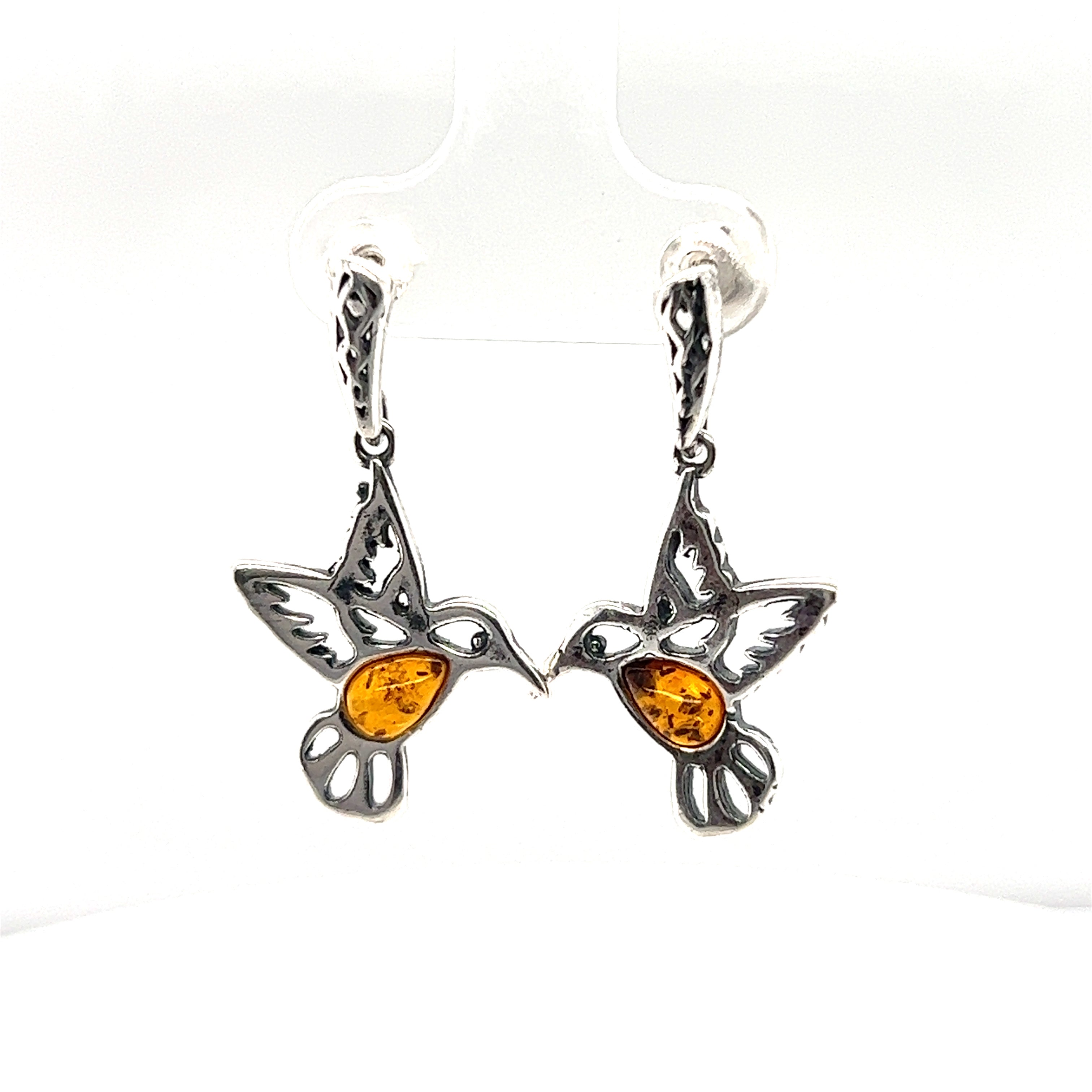 These Super Silver Amber Hummingbird Earrings are a unique addition to any jewelry collection. Handcrafted with care, these earrings showcase the timeless beauty of amber and the delicate charm of hummingbirds. Perfect for nature lovers.