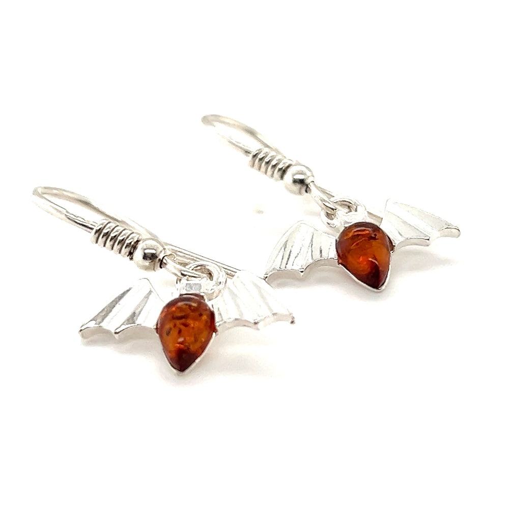 A pair of Enchanting Baltic Amber Bat Earrings from Super Silver, adorned with Baltic amber crystals, showcasing the warm hues of cognac amber.
