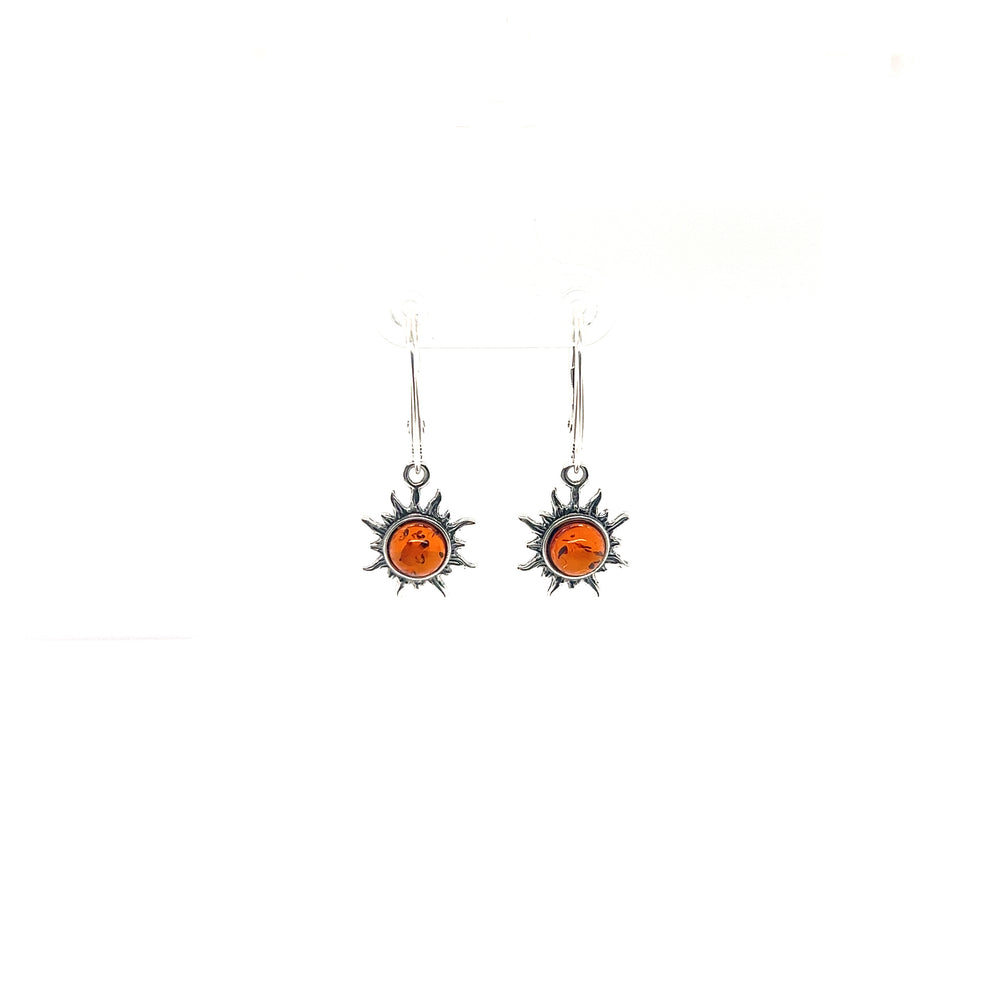 A pair of Brilliant Baltic Amber Sun Earrings adorned with Baltic amber sunstones, known for their healing properties, by Super Silver.