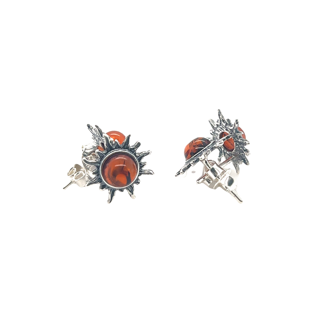A pair of Brilliant Amber Sun Stud Earrings from Super Silver with red stones and a Baltic amber sunburst design.