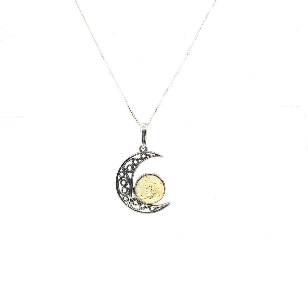 A Super Silver Stunning Filigree Amber Moon Pendant with a crescent moon and coin.