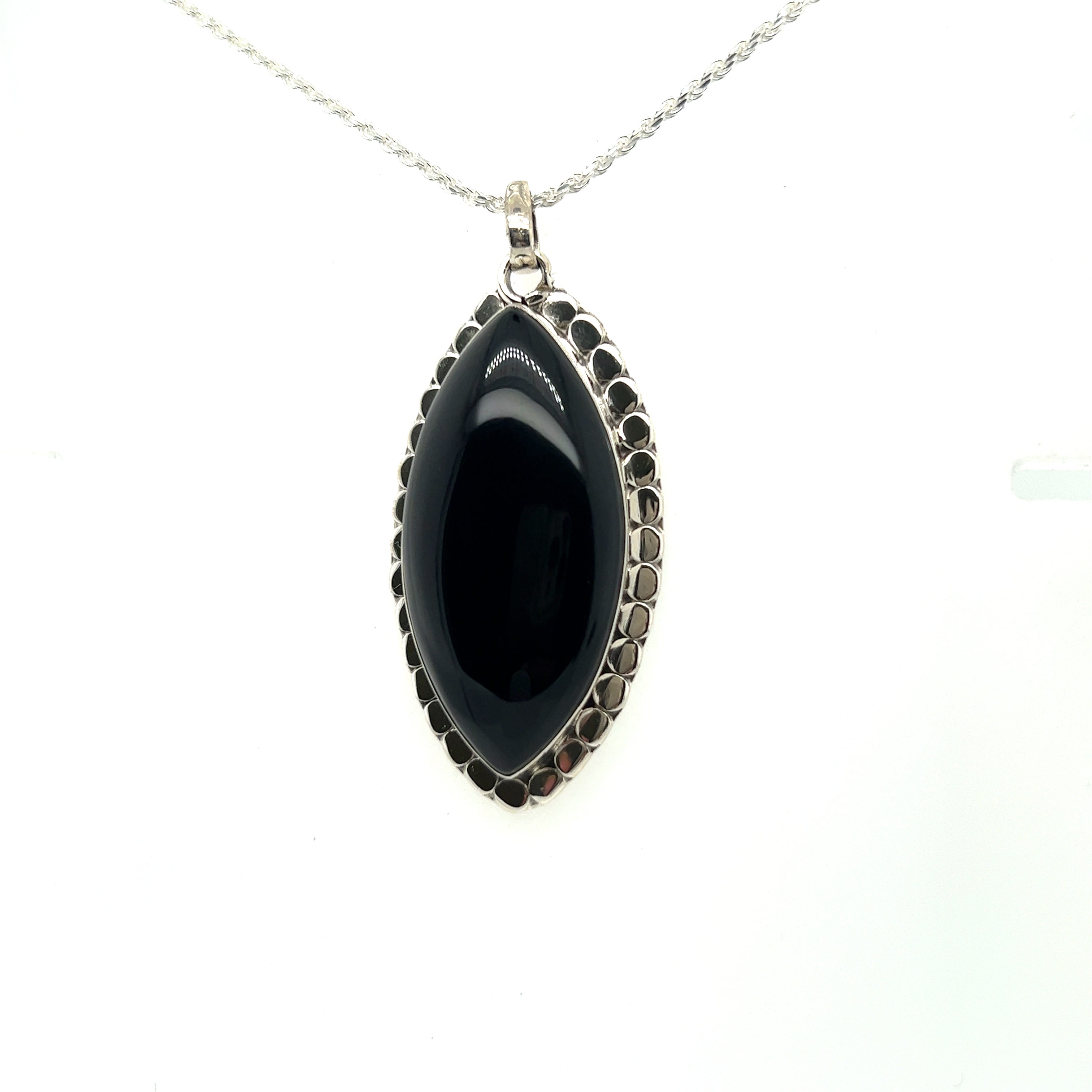 A powerful Super Silver Statement Onyx Pendant With a Textured Setting on a silver chain.