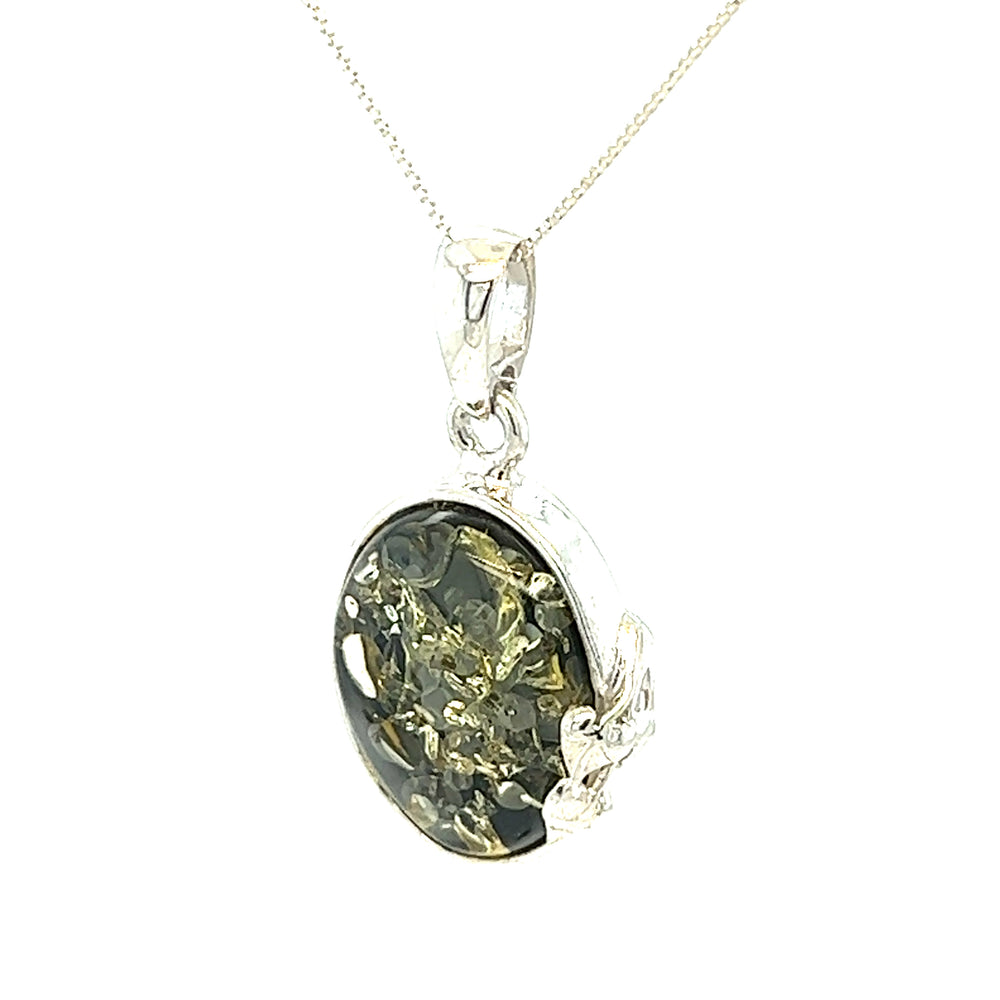 A Green Amber Oval Pendant with Delicate Leaf, with healing properties, set in a silver design inspired by nature.