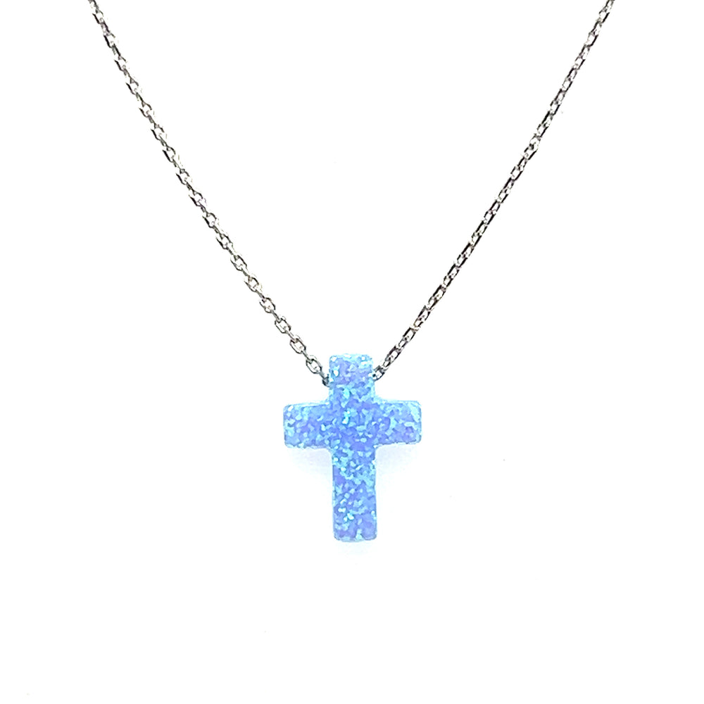 A delicate Blue Opal Cross Necklace on a chain, made with an ocean blue stone to calm and soothe by Super Silver.